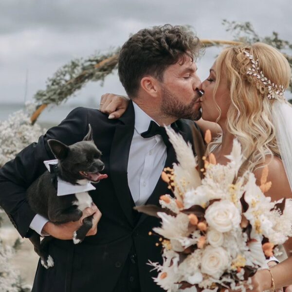 Pareja de recién casados besándose junto a su perro en una boda al aire libre en Marambay, Cádiz.